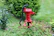 A joyful man beside a newly installed water pump, with lush greenery around.