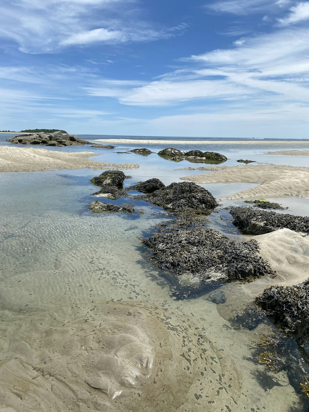 brown rocks on seashore under blue sky during daytime