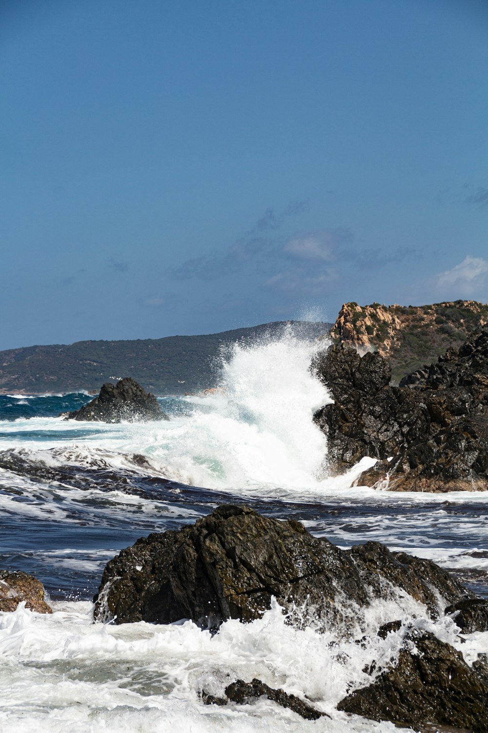 ocean waves crashing on rocky shore during daytime