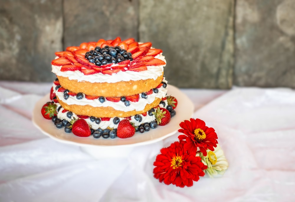 Gâteau aux fraises et aux myrtilles sur assiette en céramique blanche
