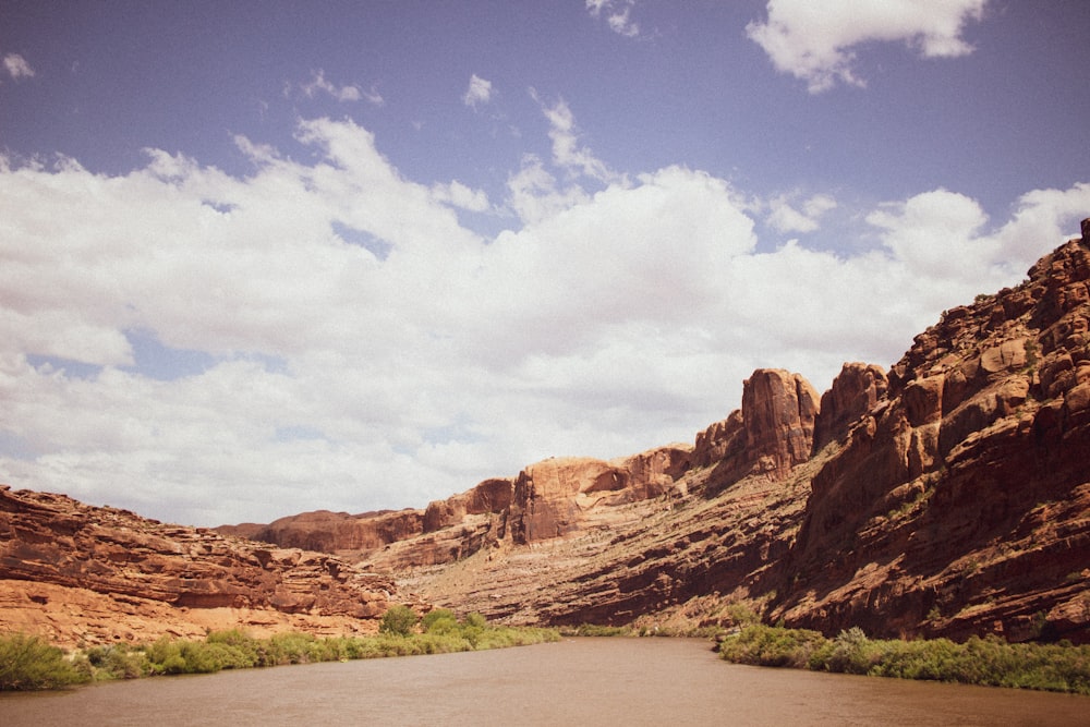 brown rock formation under blue sky and white clouds during daytime