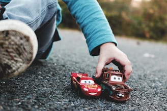 person holding red and black toy car