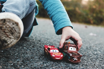 person holding red and black toy car