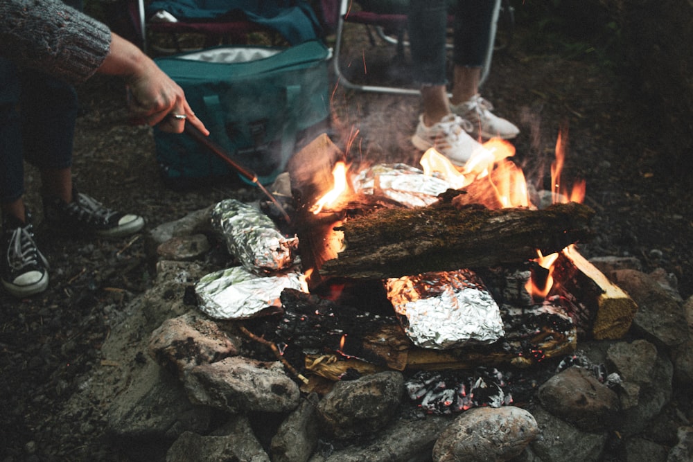 person holding stick and cooking meat