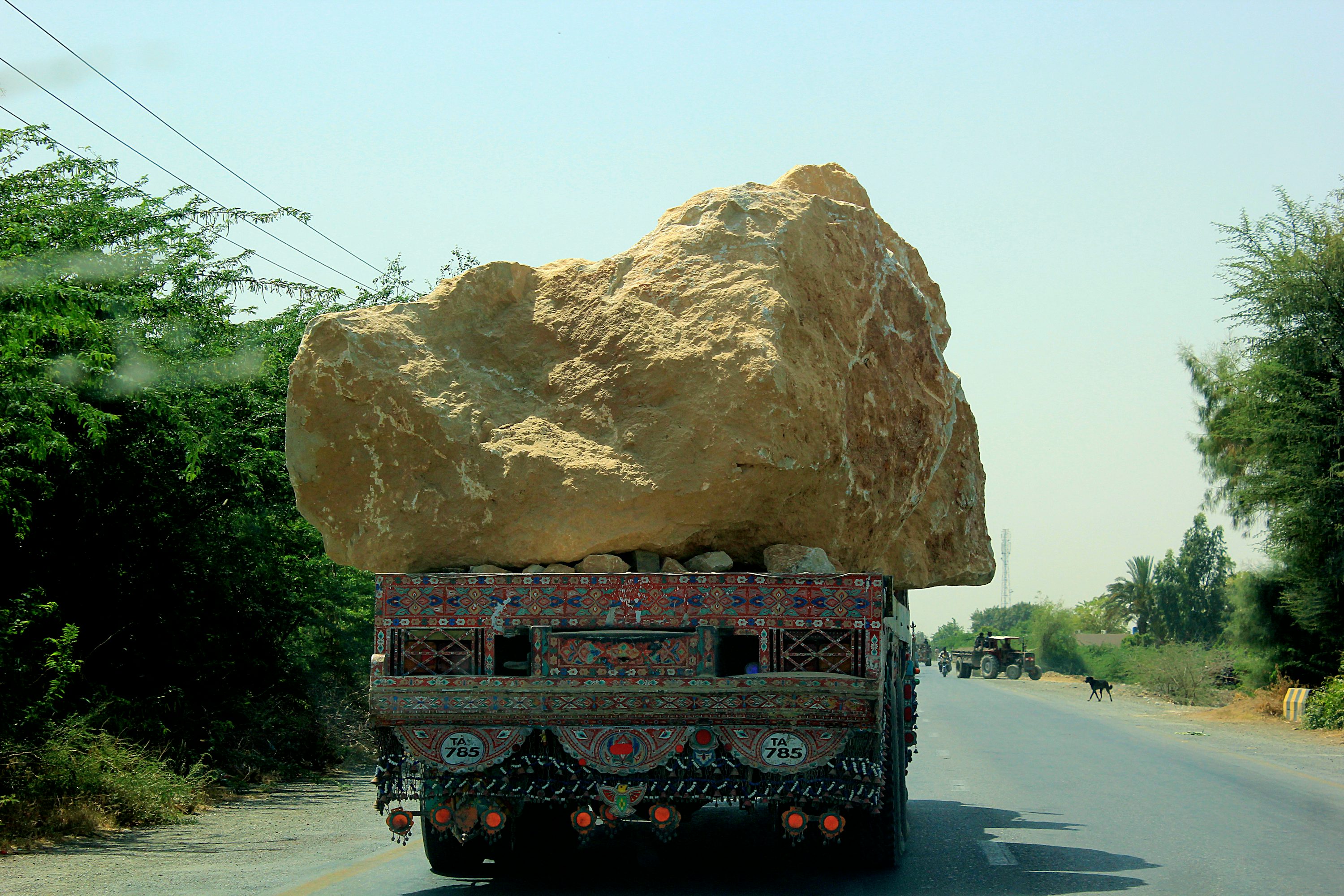 brown rock formation on gray asphalt road during daytime
