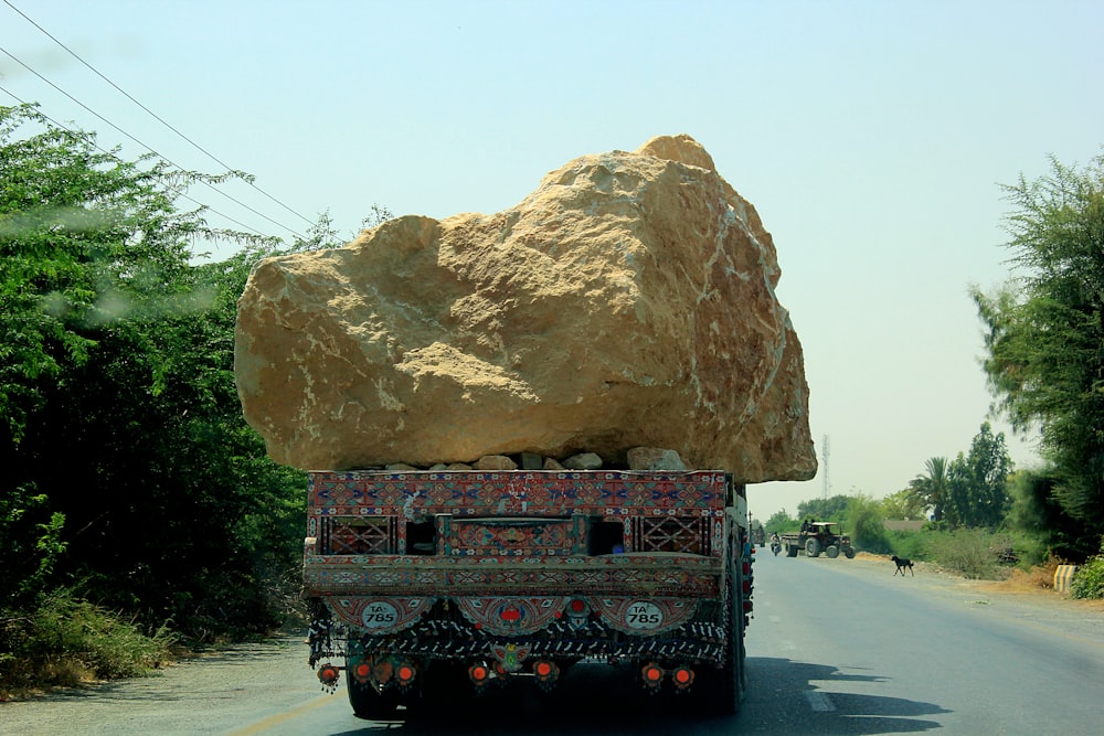 brown rock formation on gray asphalt road during daytime