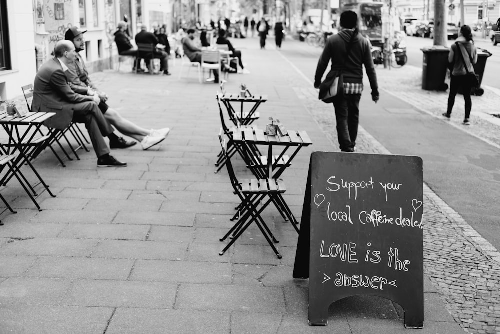 grayscale photo of people sitting on bench