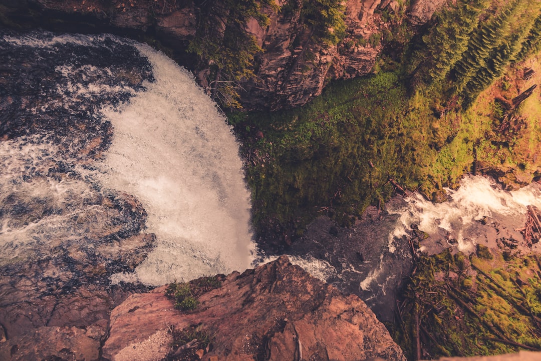 water falls on brown rocky mountain