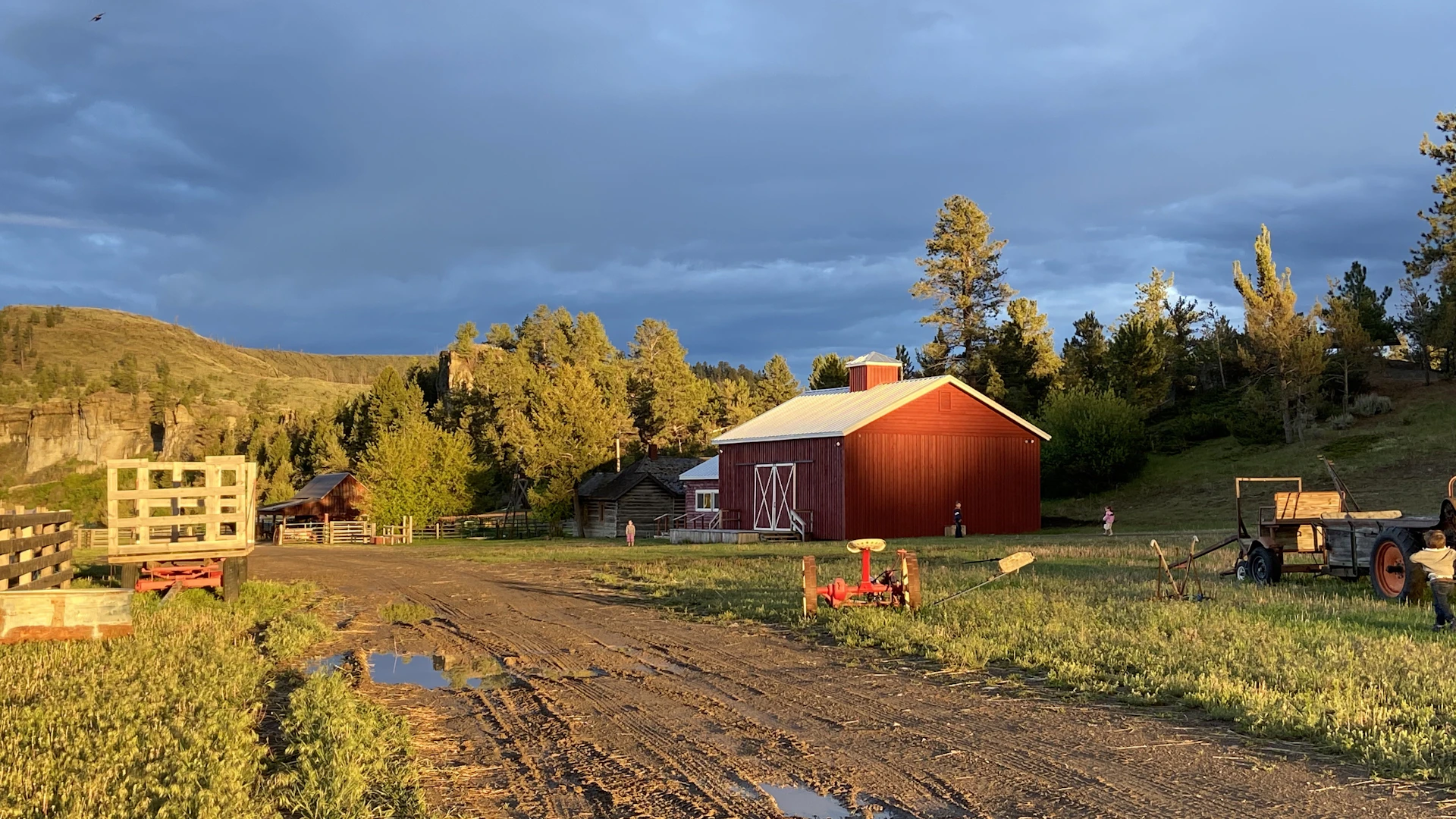 red wooden barn near green trees under white clouds during daytime