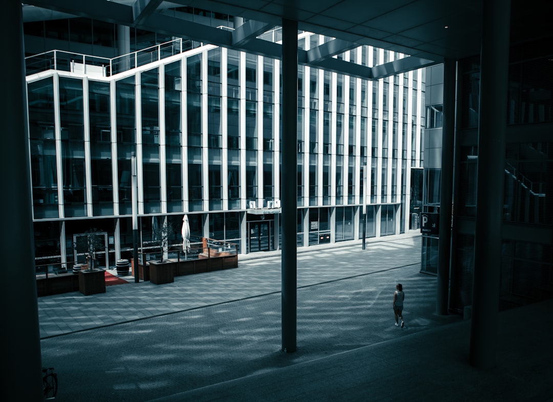 people walking on sidewalk near glass building during daytime