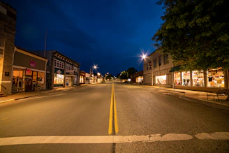 Evening shot of a retail street with illuminated shopfronts and calm atmosphere.