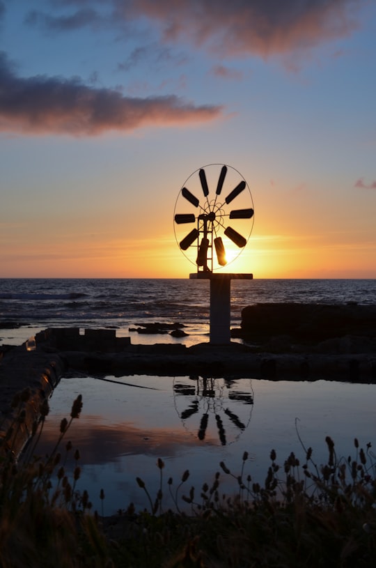silhouette of windmill near body of water during sunset in Batroun Village Club Lebanon