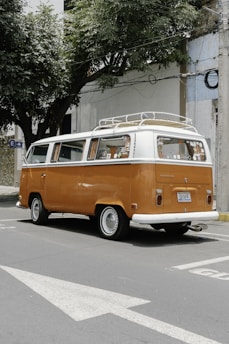 orange and white volkswagen t-2 parked on sidewalk during daytime