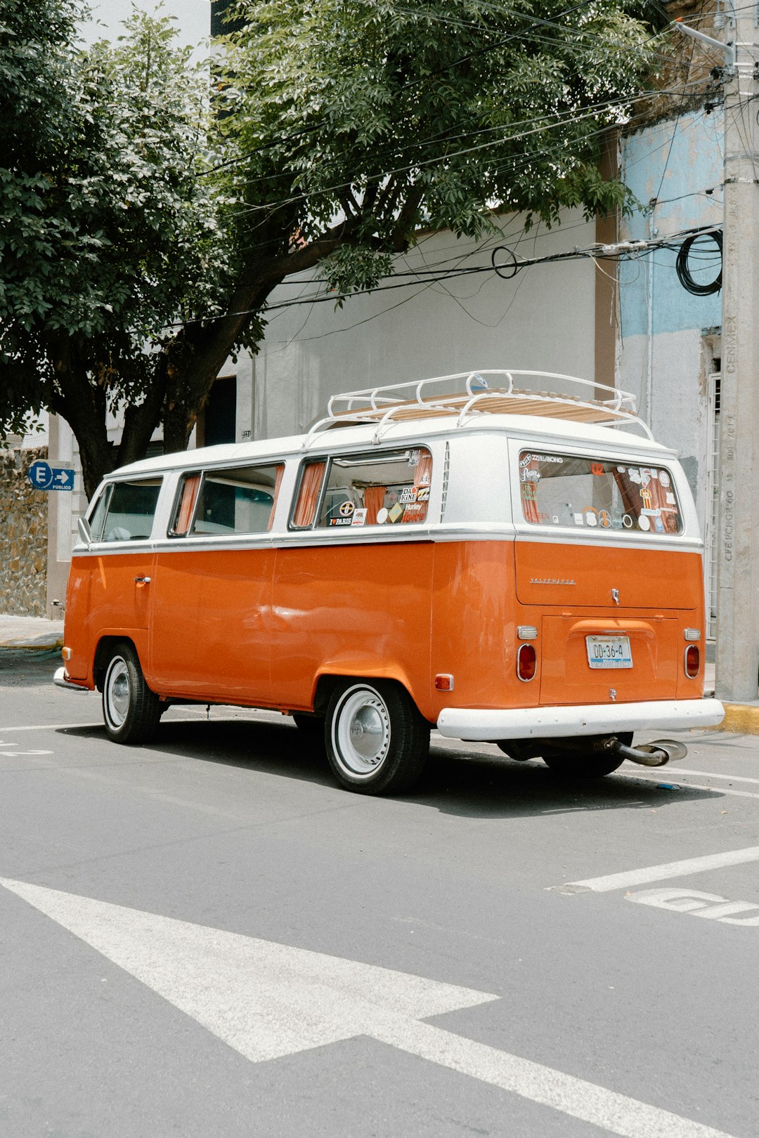 orange and white volkswagen t-2 parked on sidewalk during daytime