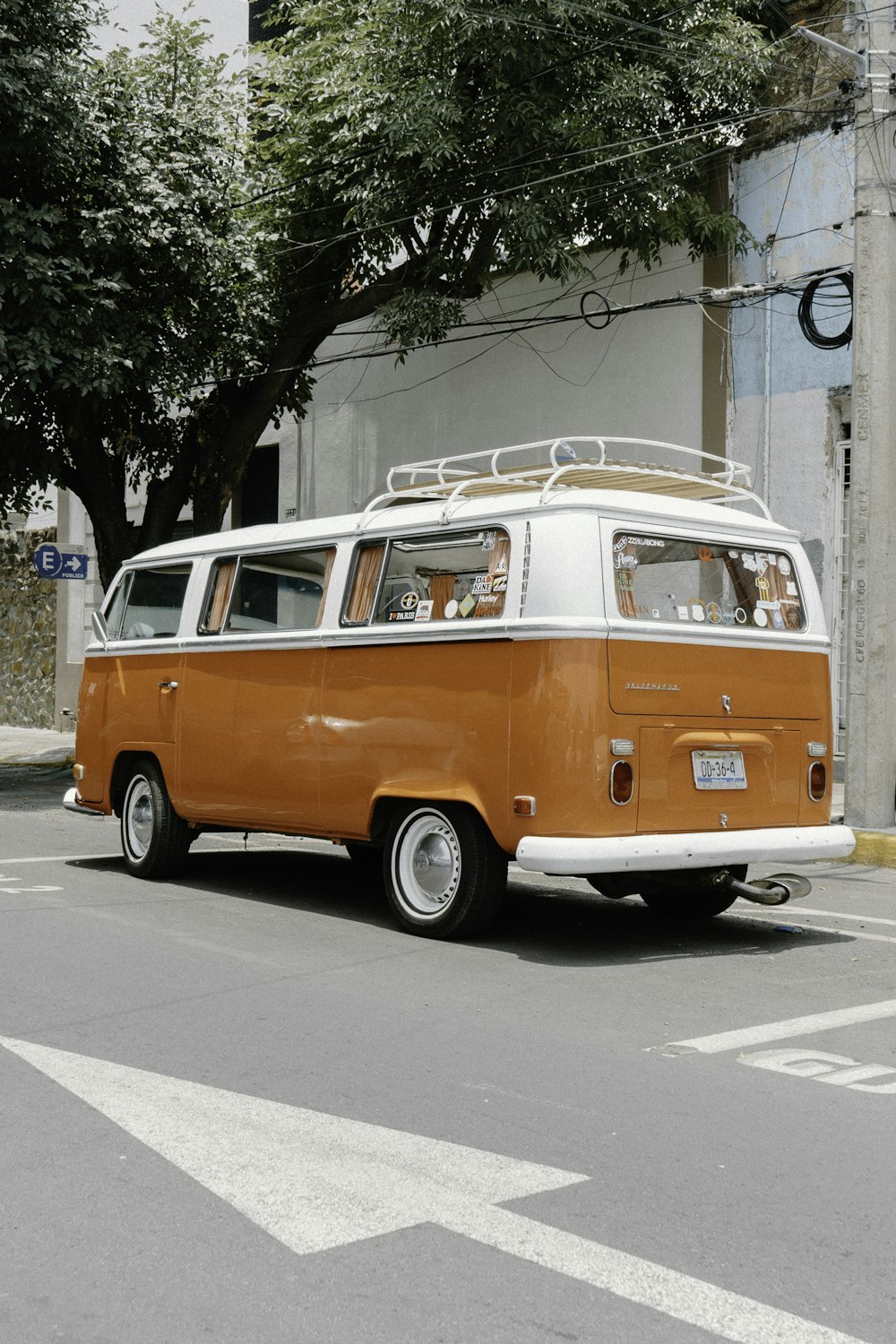 orange and white volkswagen t-2 parked on sidewalk during daytime