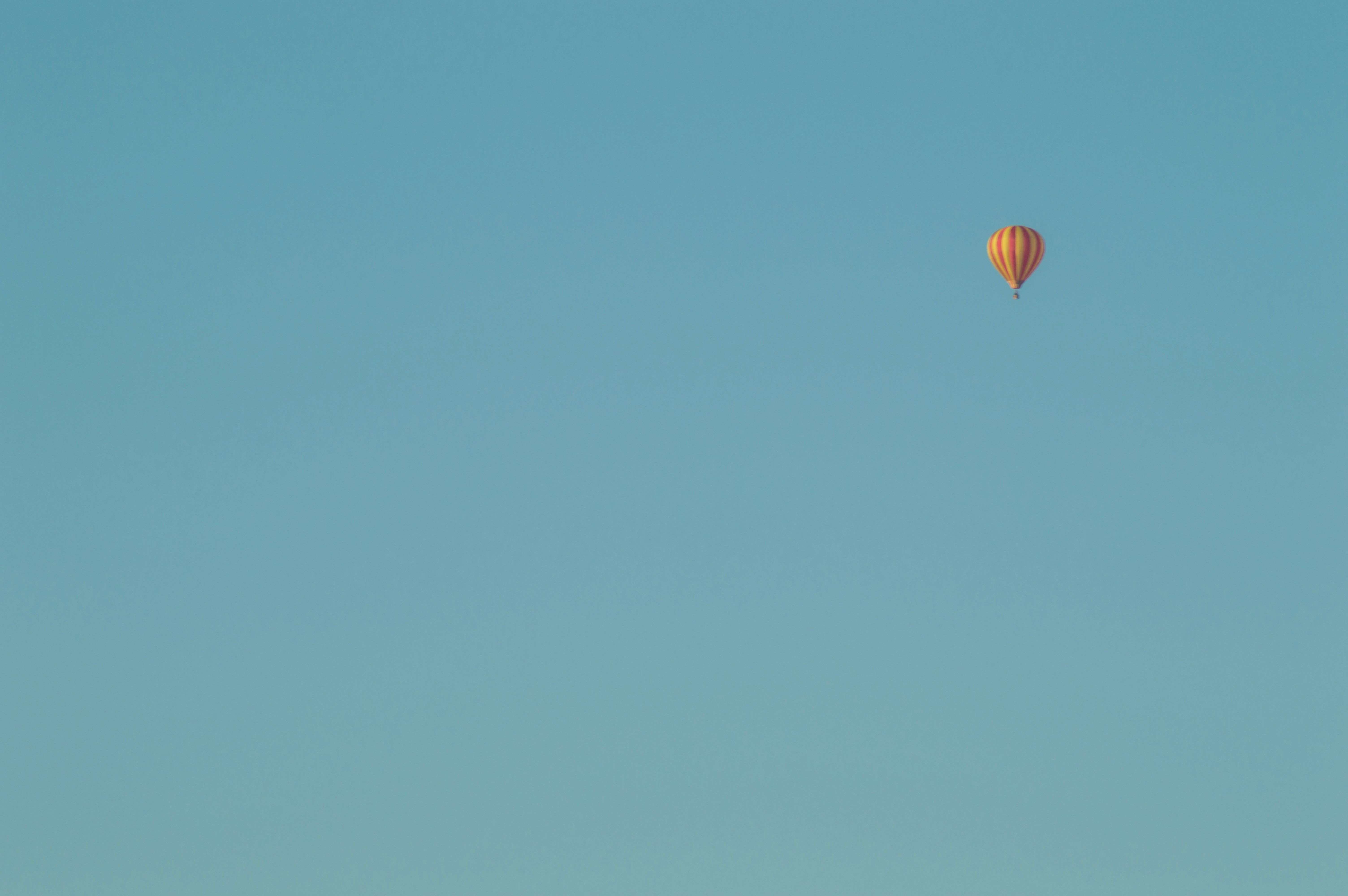 a hot air balloon flying through a blue sky