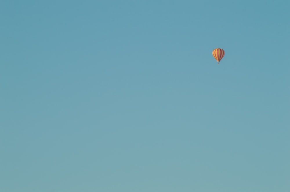 a hot air balloon flying through a blue sky