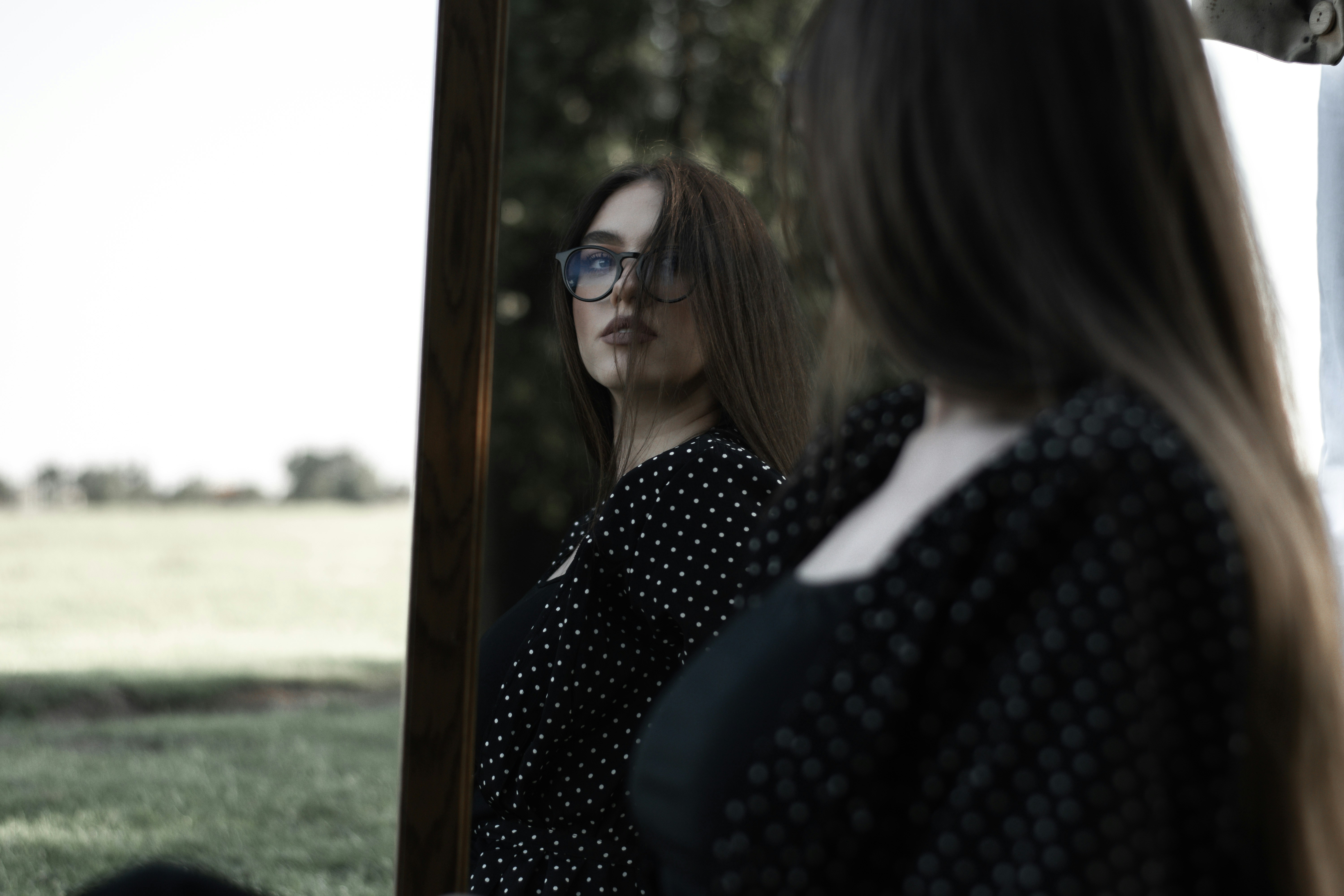 woman in black and white polka dot shirt wearing black sunglasses