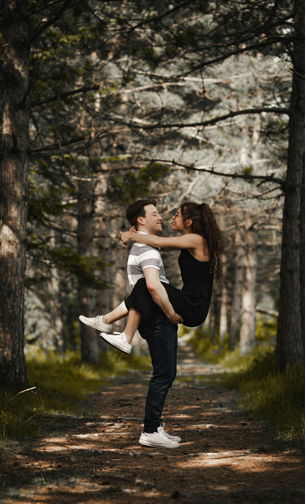 man and woman kissing near brown tree during daytime