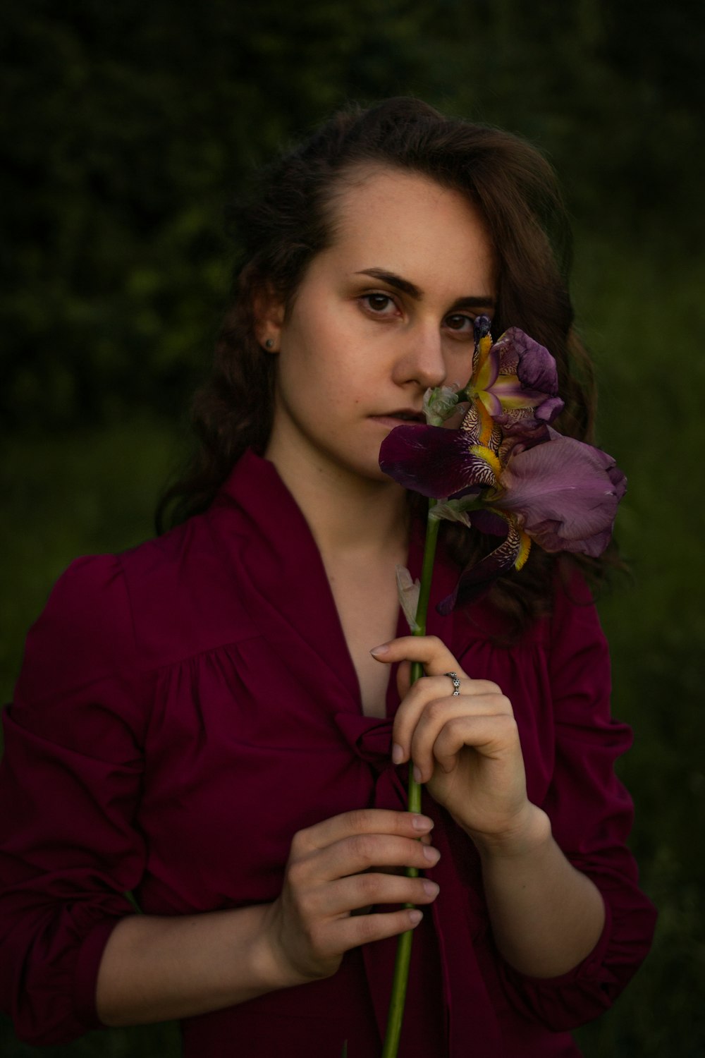 woman in purple zip up jacket holding purple flower