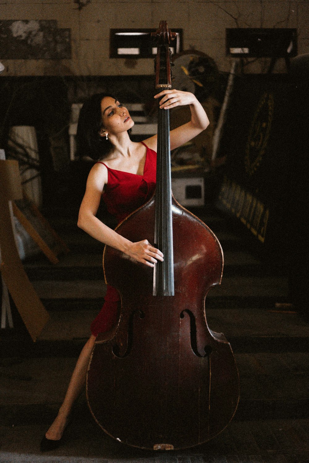 woman in red tank top and red skirt sitting on brown wooden staircase