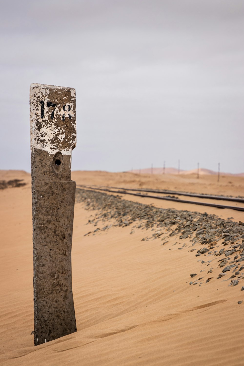 brown wooden post on brown sand during daytime