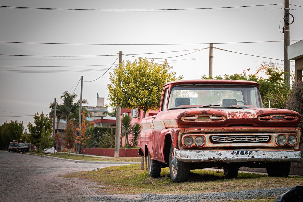 Roter Chevrolet Single Cab Pickup tagsüber am Straßenrand geparkt