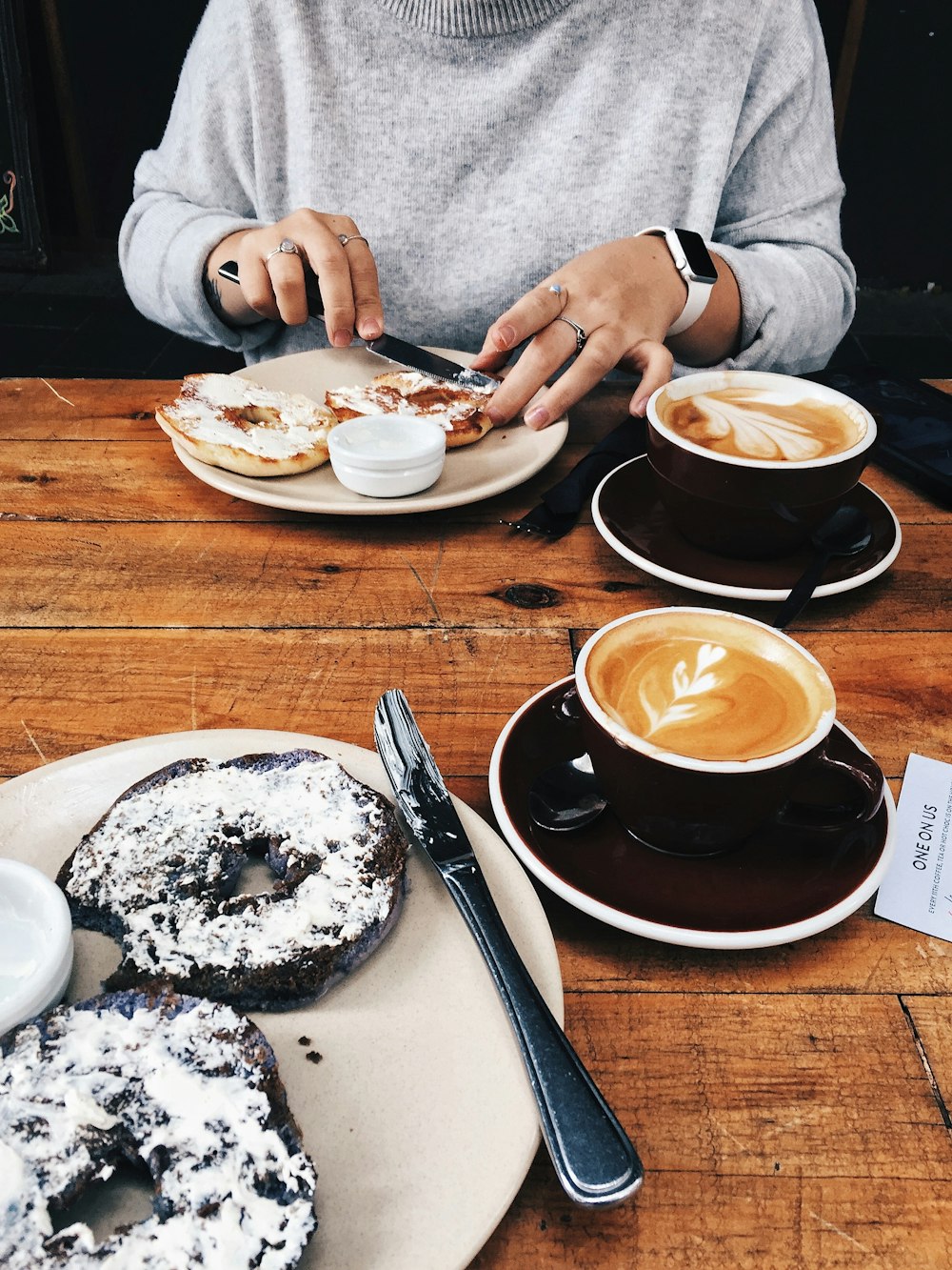 person in white long sleeve shirt holding white ceramic plate with white ceramic bowl and saucer