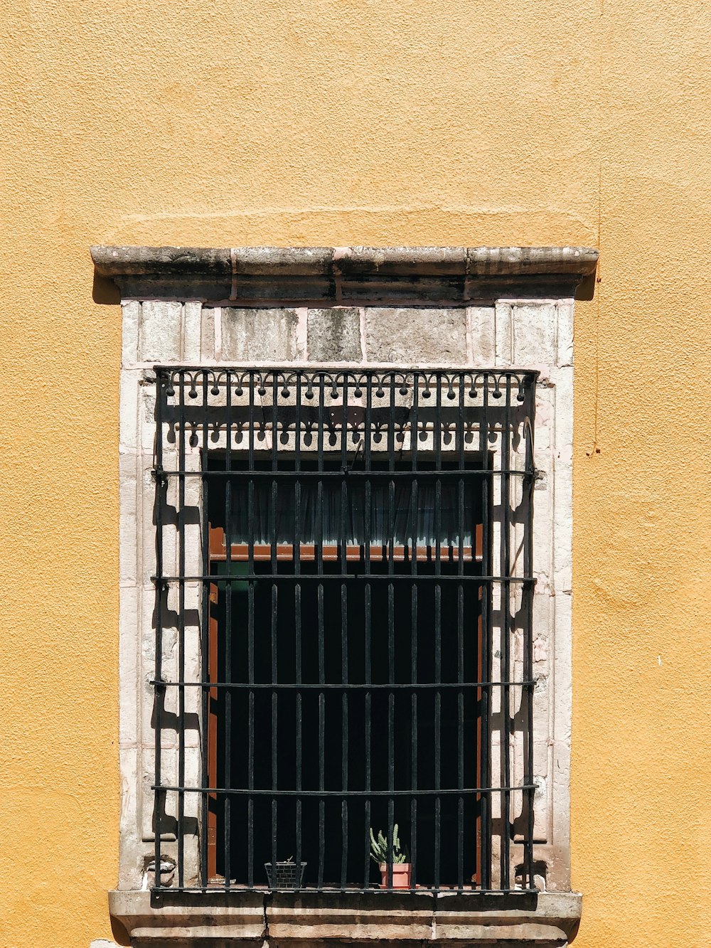 blue metal window grill on brown concrete wall