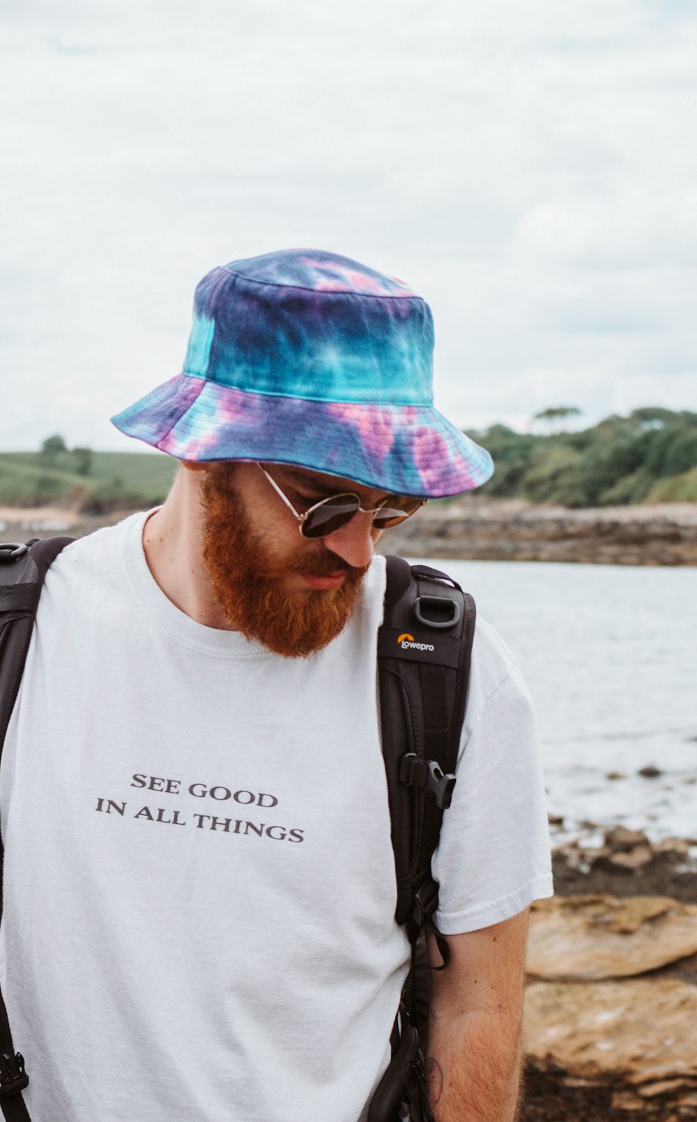 man in white crew neck shirt wearing blue and purple plaid cap