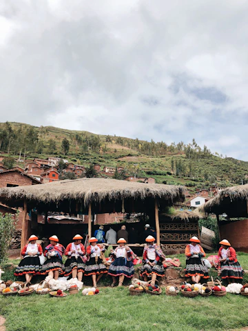 A group of Ecuadorian women artisans weaving colorful textiles in a sunlit workshop by the coast.