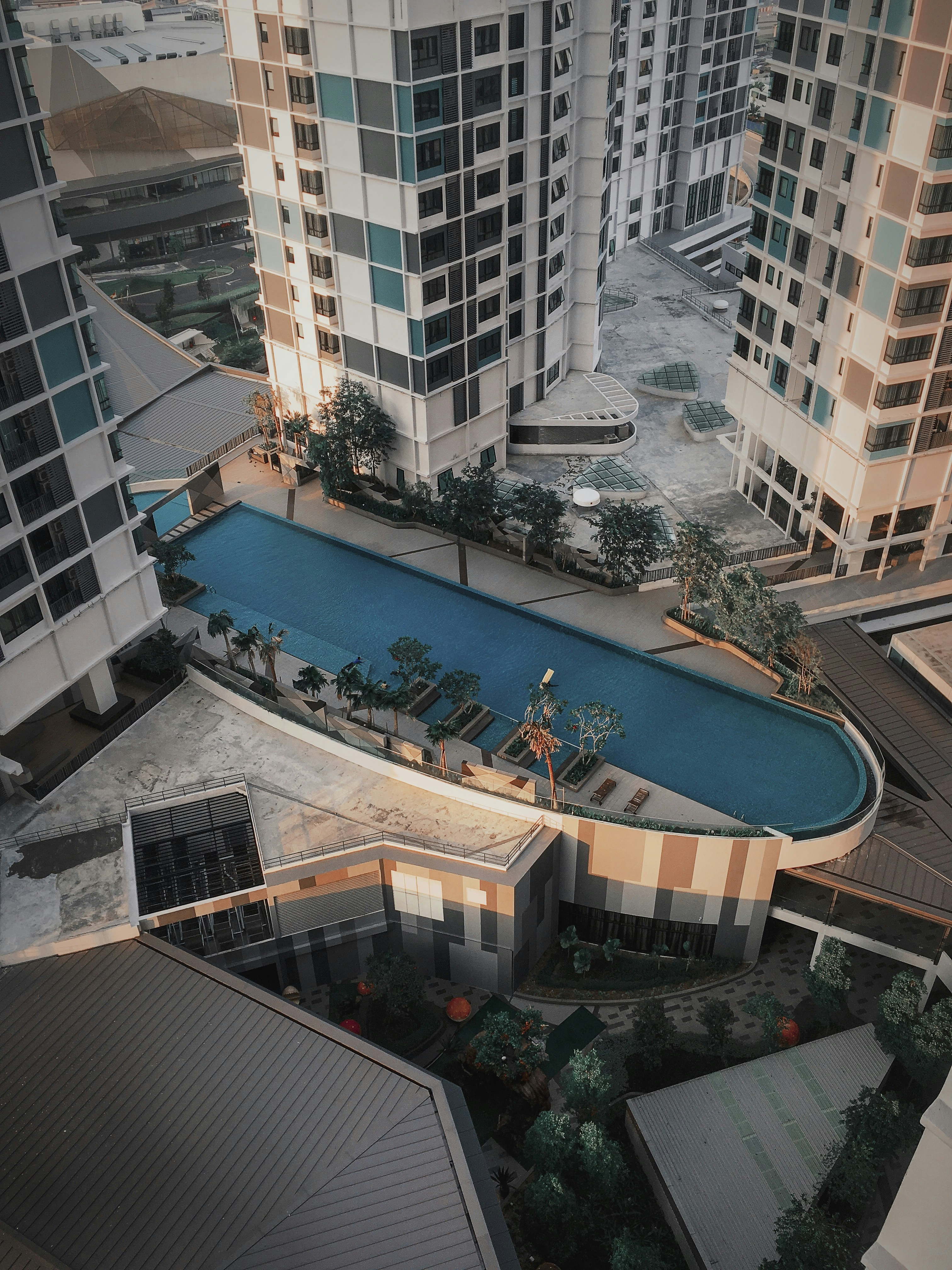Modern apartment complex with rooftop pool in Marbella, aerial view, Mediterranean coastline background