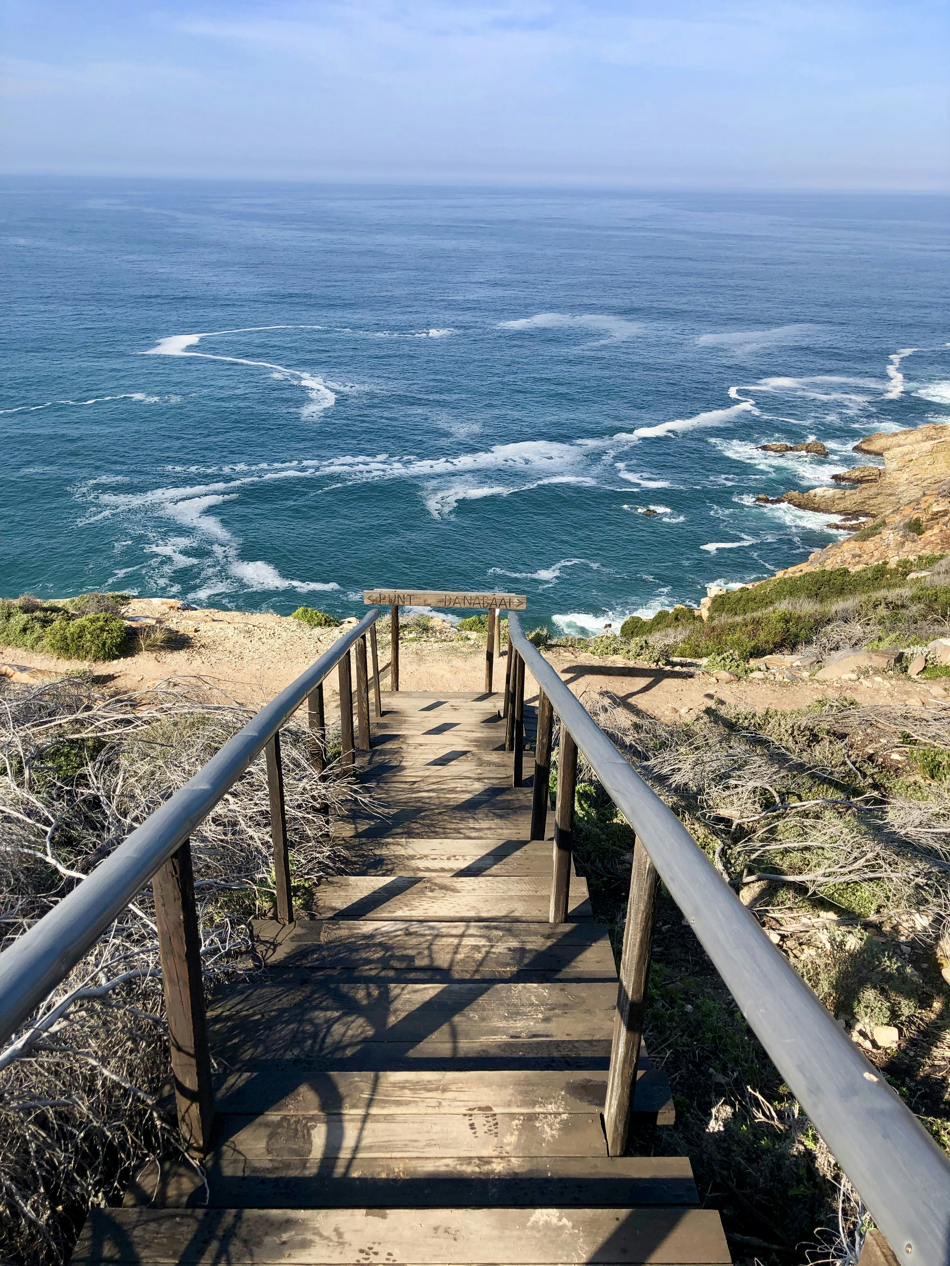 brown wooden staircase on seashore during daytime