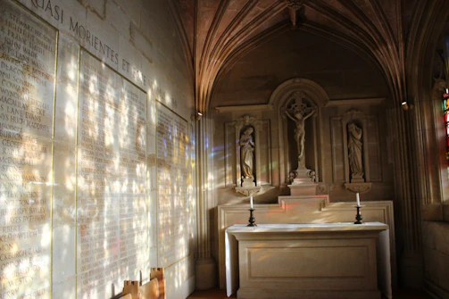 A peaceful chapel interior with stained glass casting colorful light on a simple wooden altar.