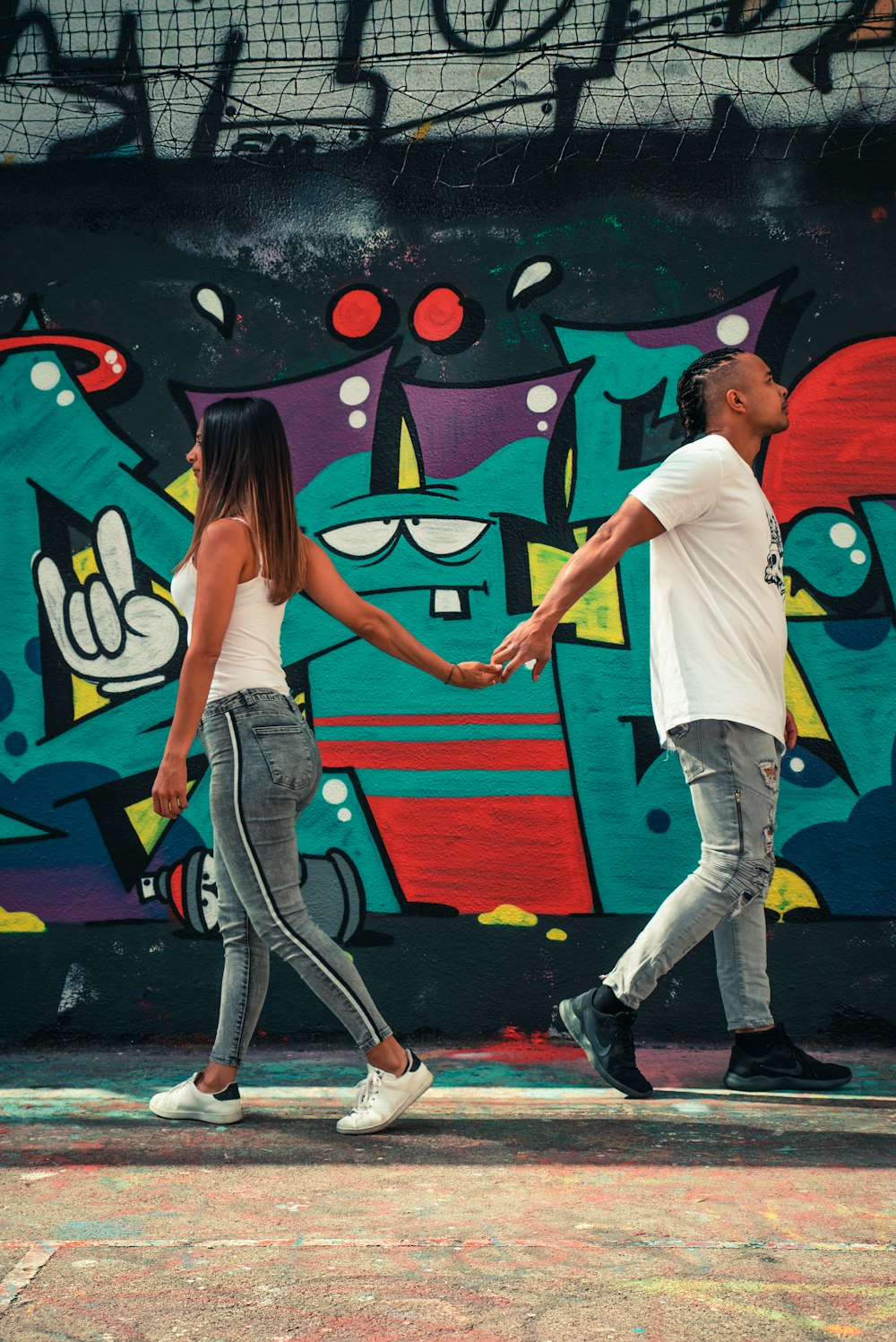 man and woman holding hands while walking