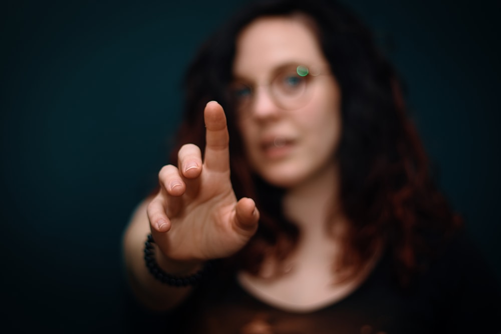 woman in black shirt showing her middle finger