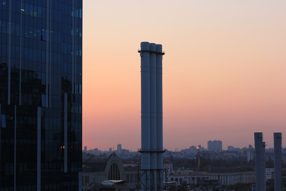 Weißer Betonturm in der Nähe von Stadtgebäuden tagsüber