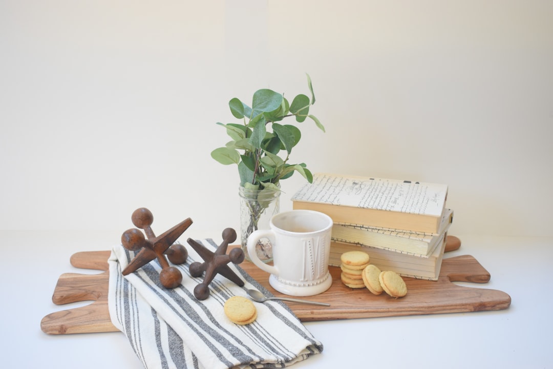 white ceramic mug beside brown wooden rolling pin and brown wooden rolling pin