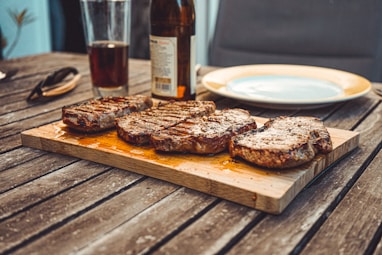 Strip steaks on brown wooden board