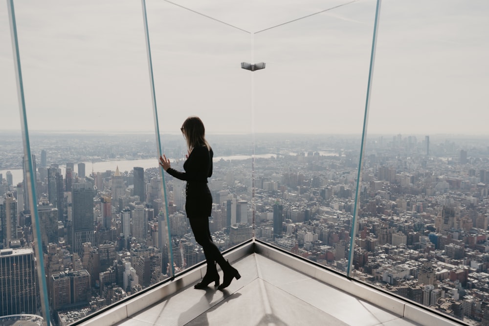 man in black jacket and black pants standing on top of building during daytime