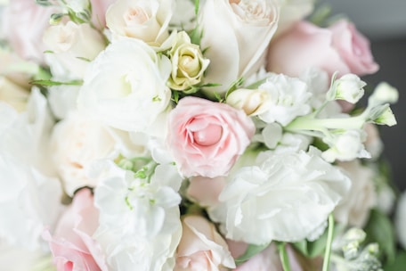 Close-up of a delicate bridal bouquet with soft pink roses and greenery.