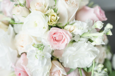 A close-up of a delicate bridal bouquet featuring soft roses and greenery.