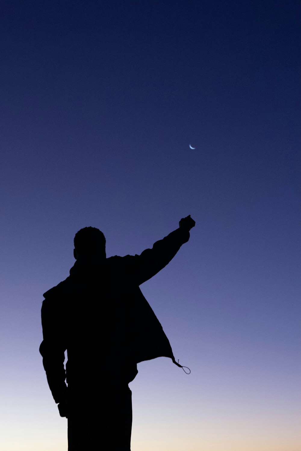 silhouette of man holding a rope during night time