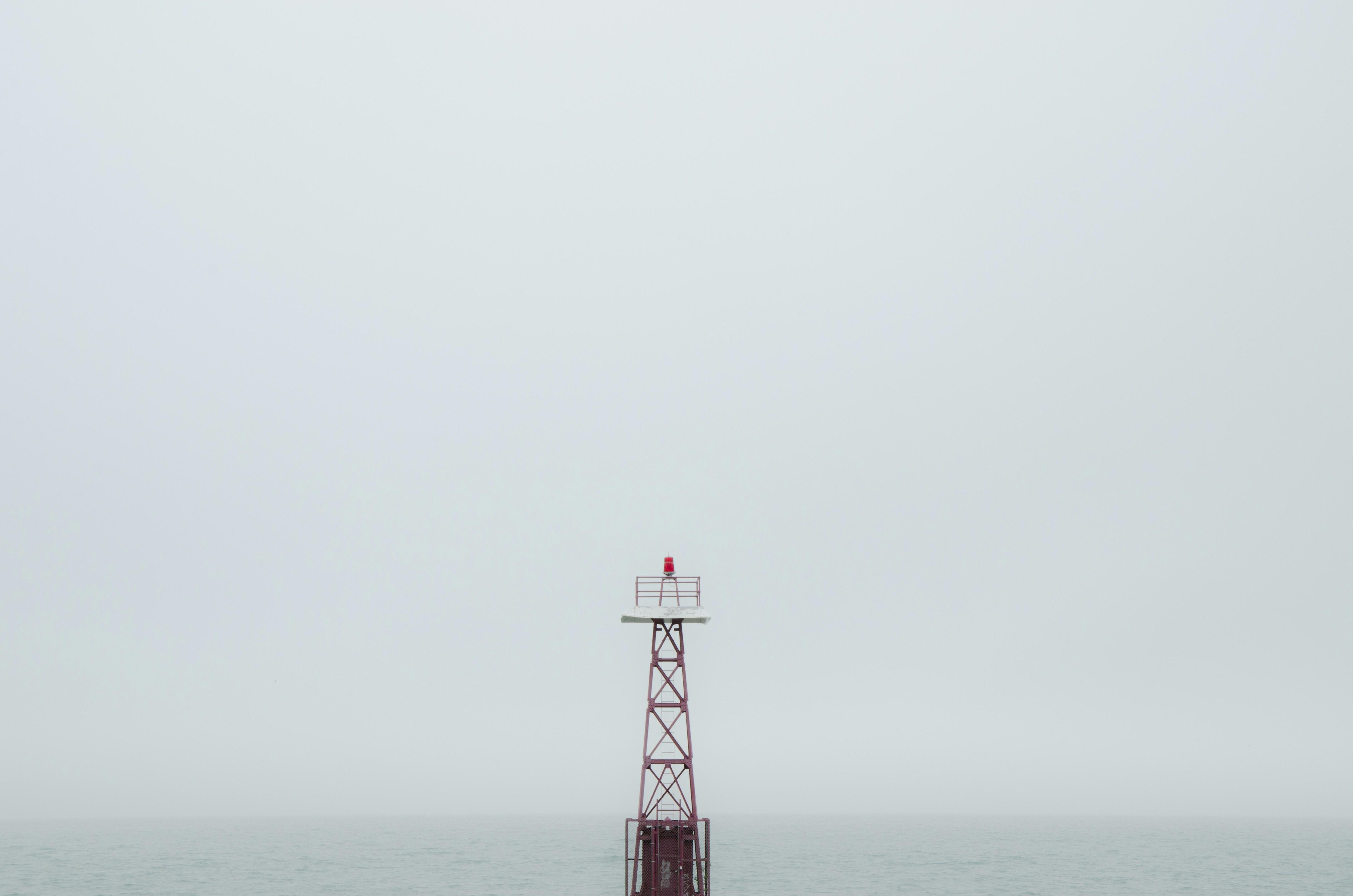 red and white tower on the sea