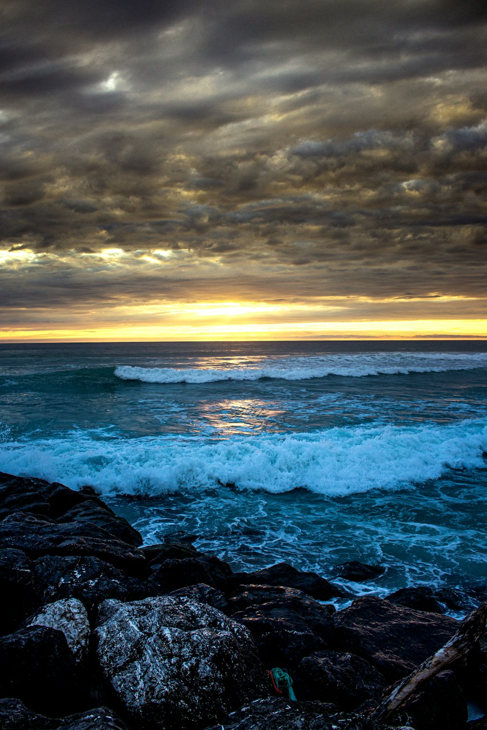 ocean waves crashing on rocks during sunset