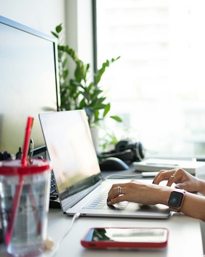 Person sitting at a desk staring at a laptop screen, looking distracted instead of working