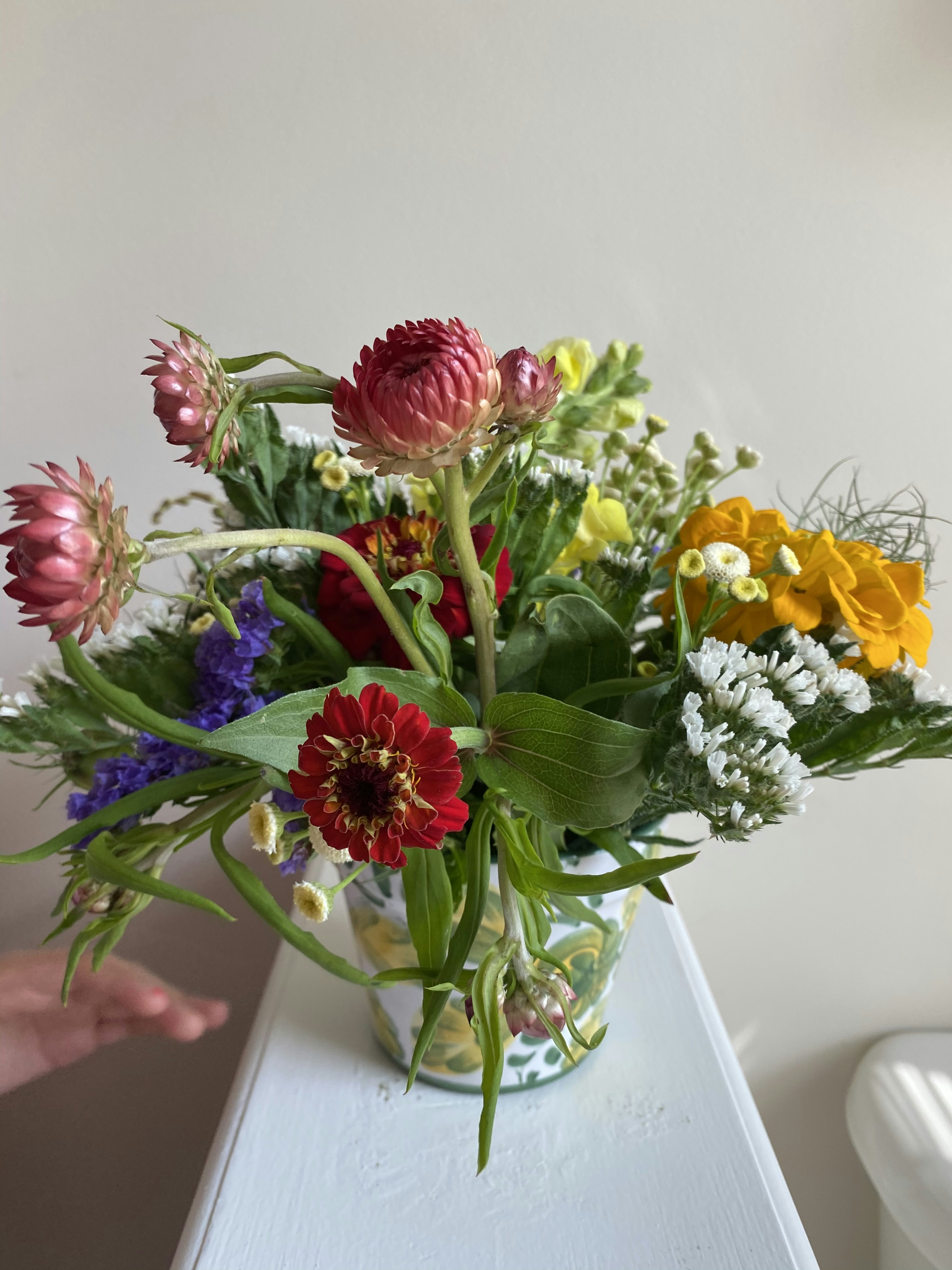 Colorful mixed wildflower bouquet with purple, yellow and white blooms in rustic vase