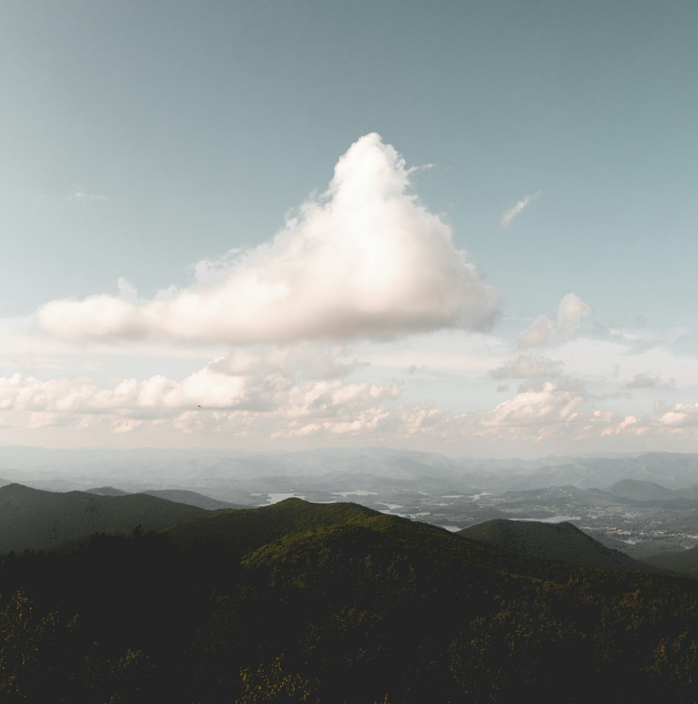 white clouds over green mountains