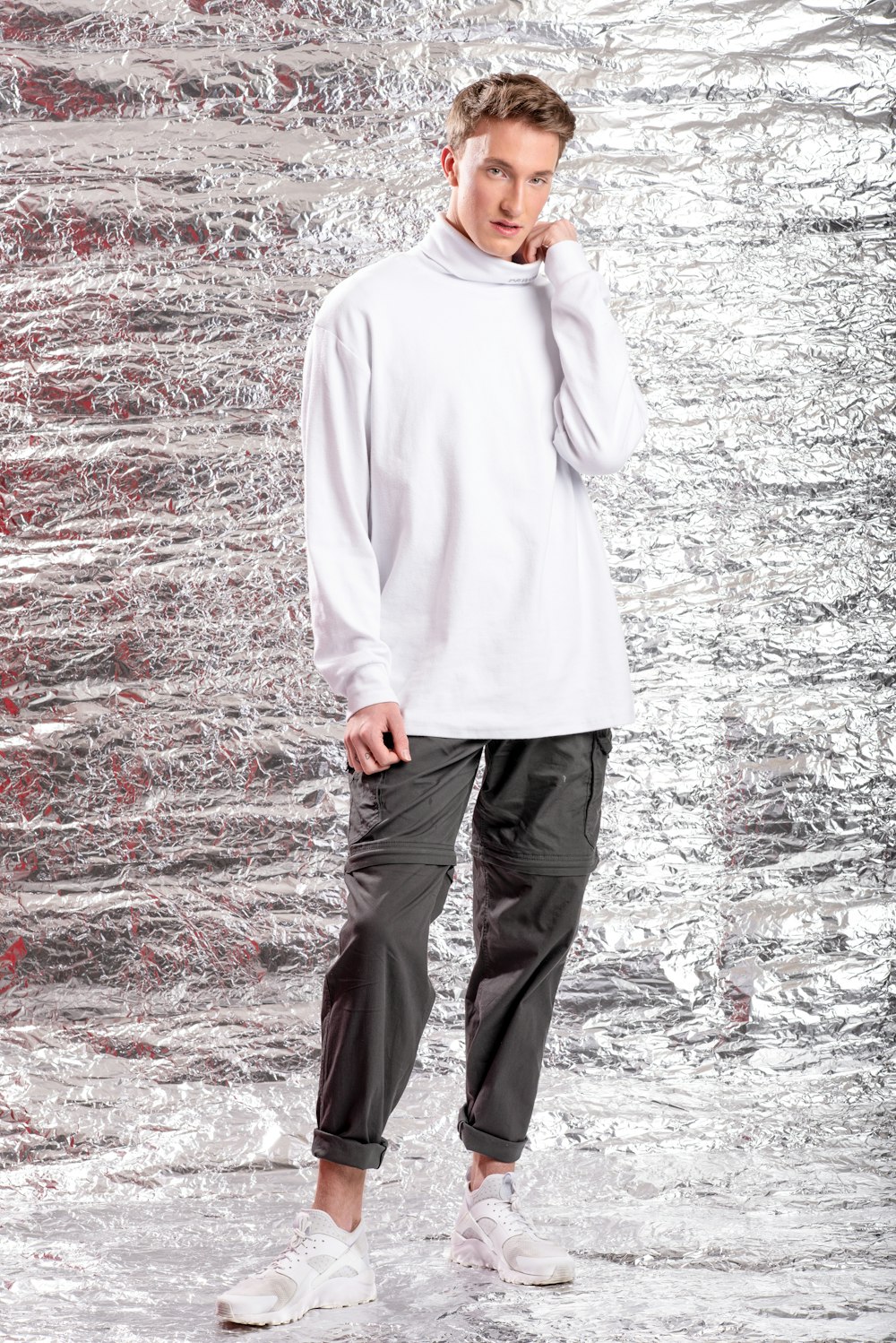 man in white hoodie standing on red and white field