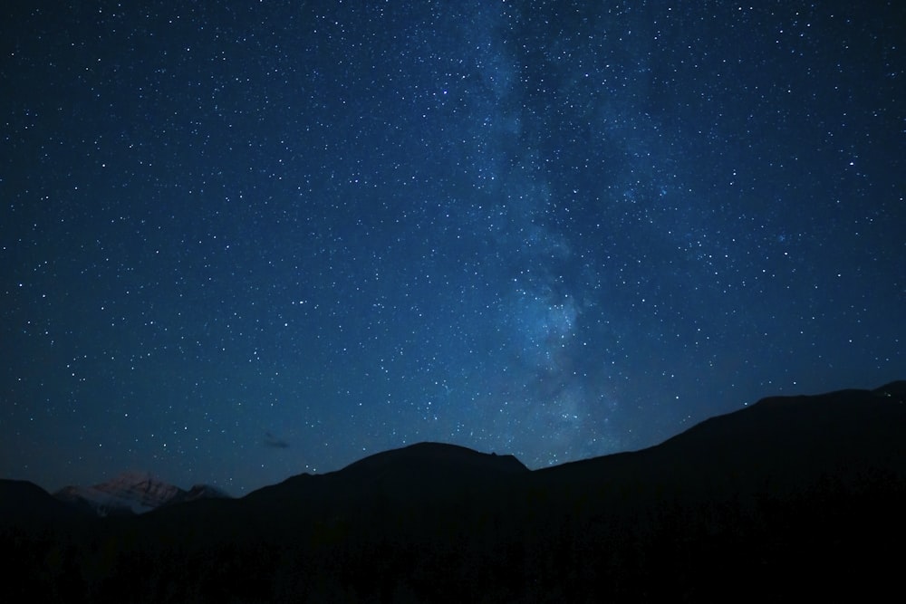 silhouette of mountain under blue sky during night time